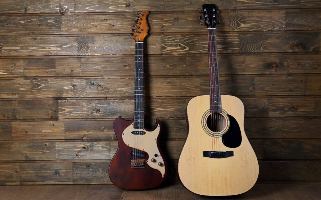 Acoustic and electric guitars on wooden background