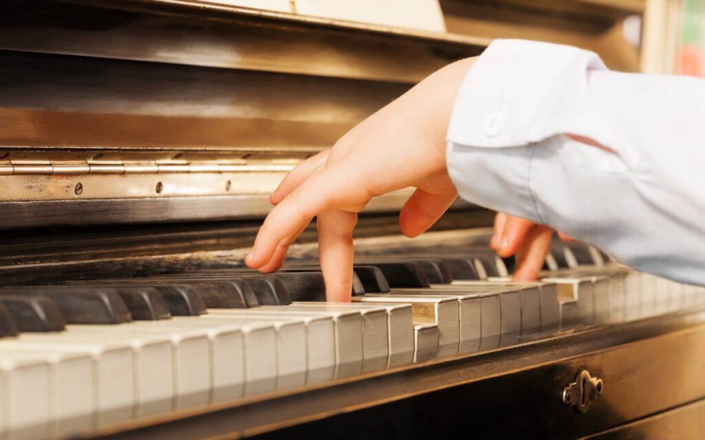 Child's hands playing on piano