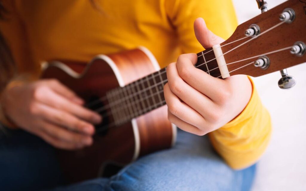 Closeup of a girl playing ukulele