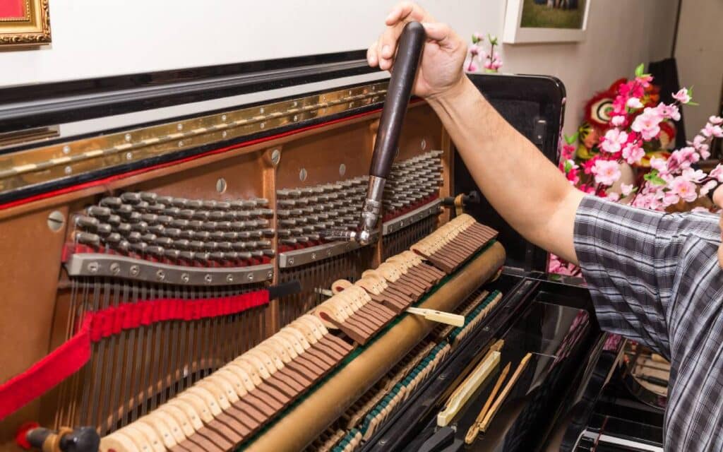 Closeup on hand tuning an upright piano