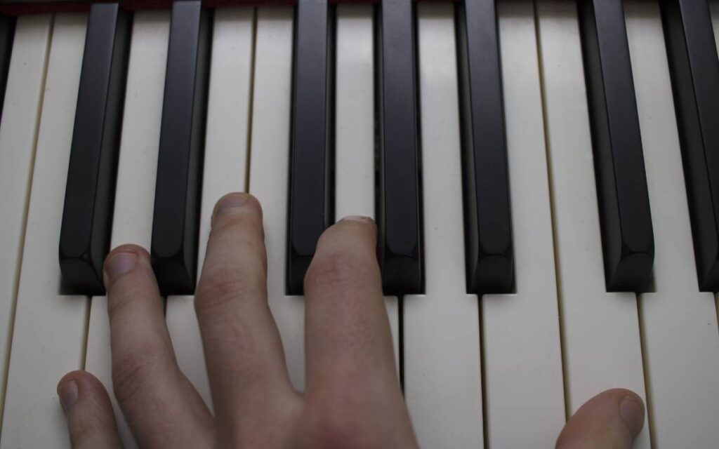 Fingers resting on piano keys