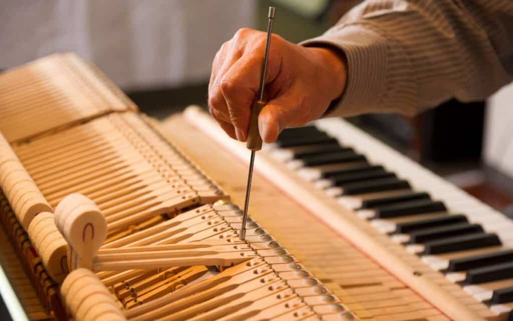 Hand of a man tuning a piano