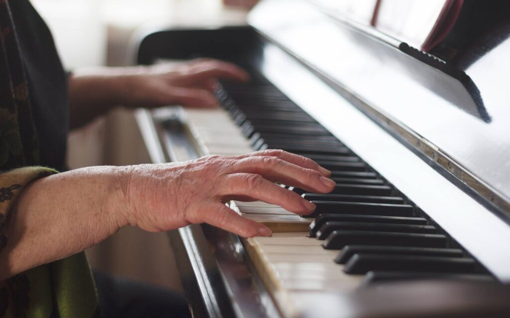 Hands of an old lady playing the piano
