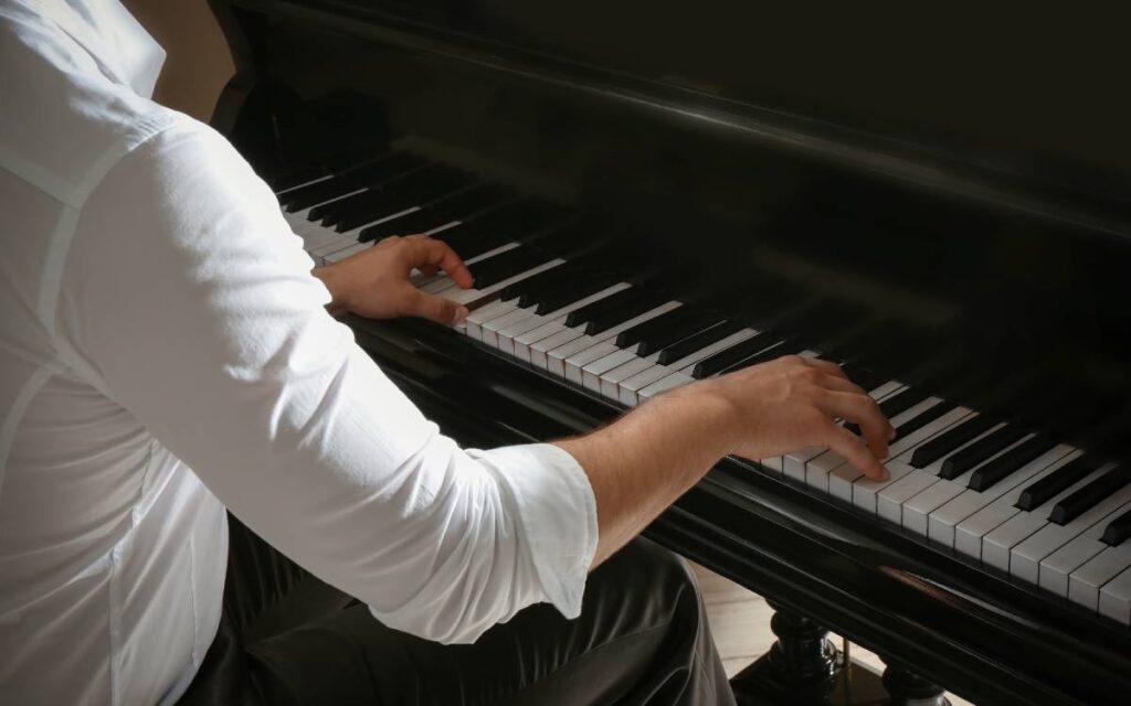 Male hands playing piano