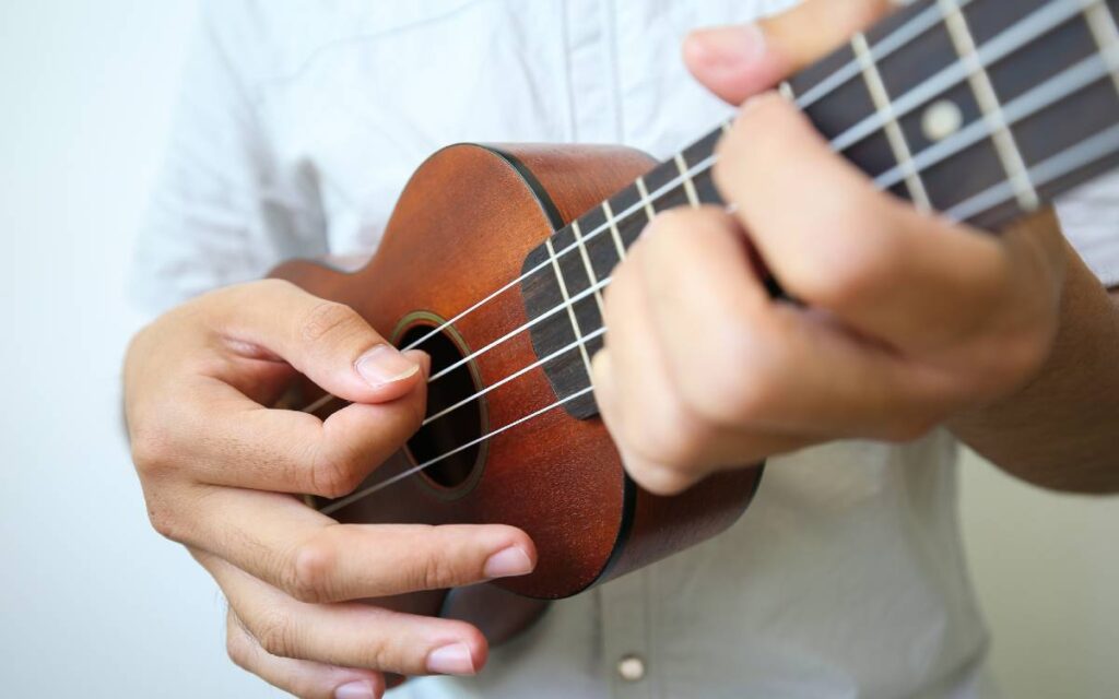 Man playing ukulele on white background