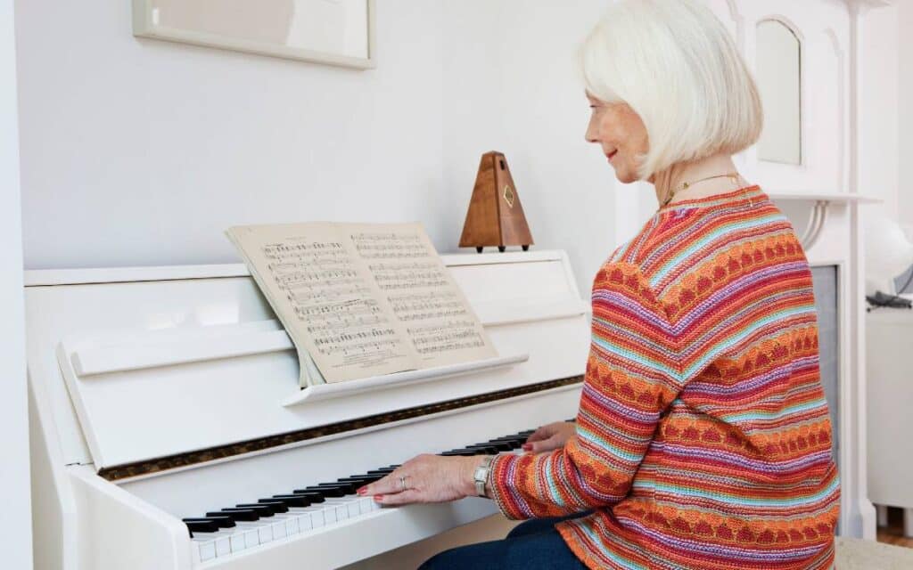 Smiling old lady playing piano