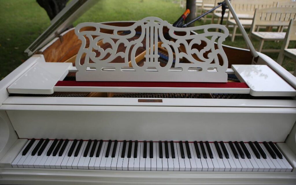 White vintage grand piano outside