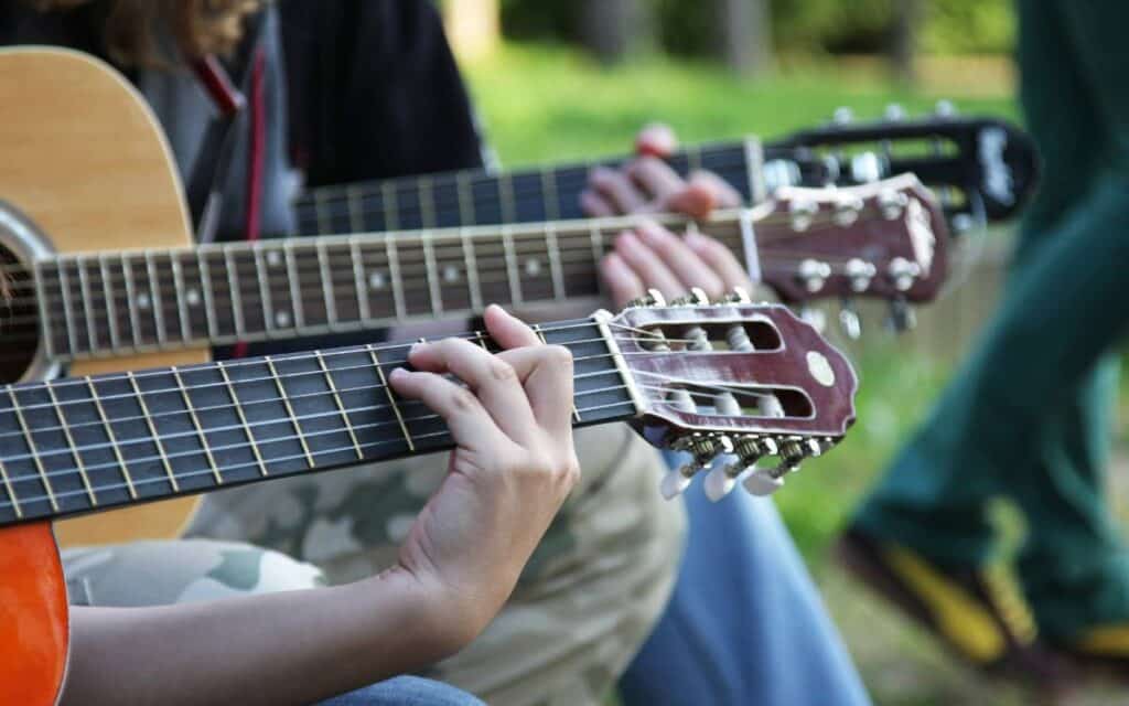 View of three guitars played by three people