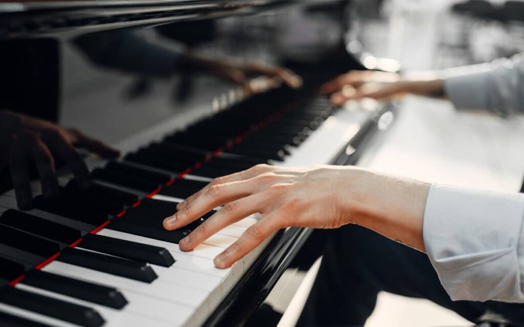 Male pianist hands on a grand piano