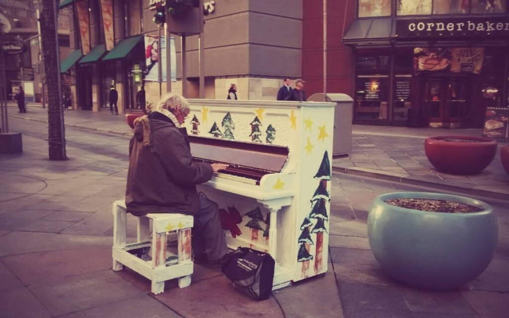Old man plays street piano
