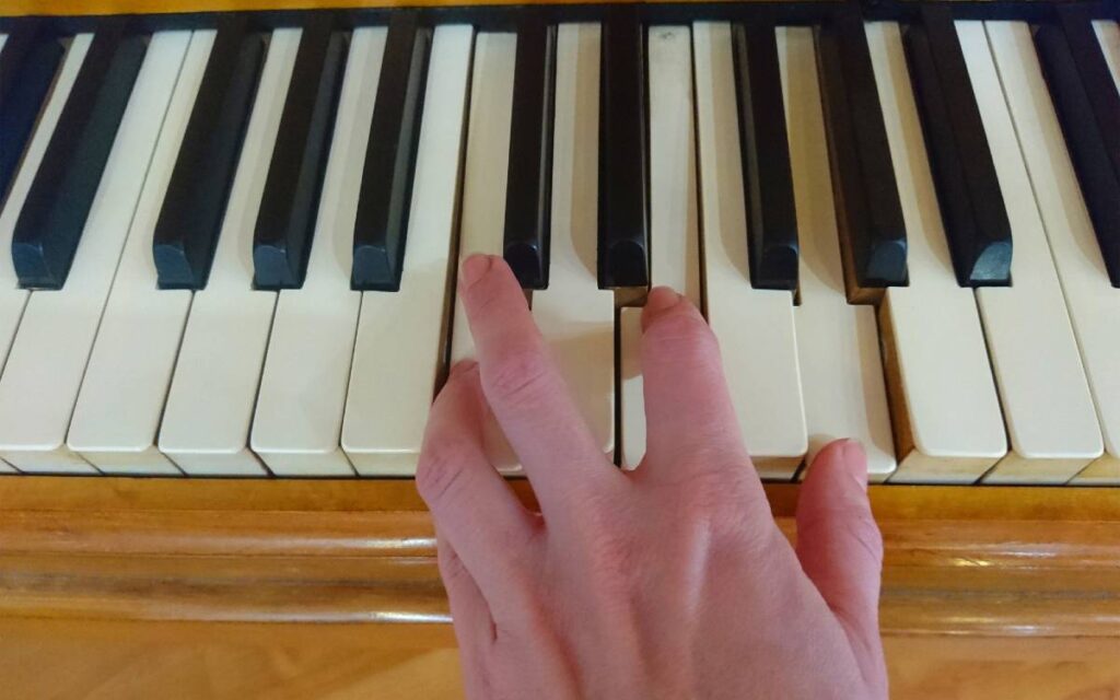 One hand playing the piano