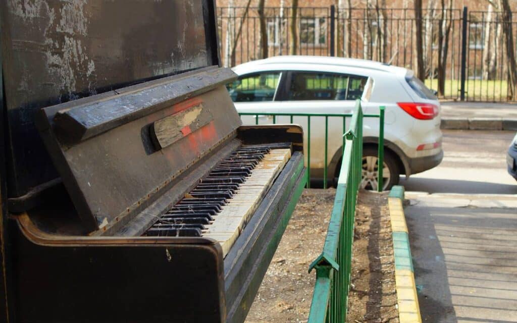 Piano outside near cars passing by