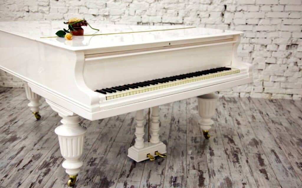 Beautiful white grand piano with yellow rose on top