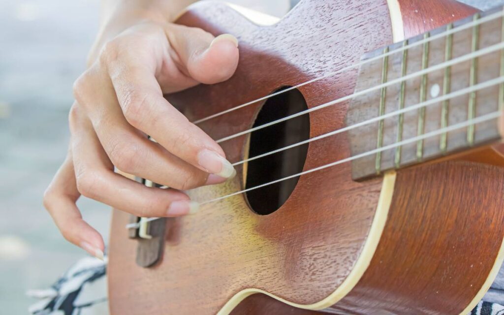 Close up of a woman's hand playing ukulele
