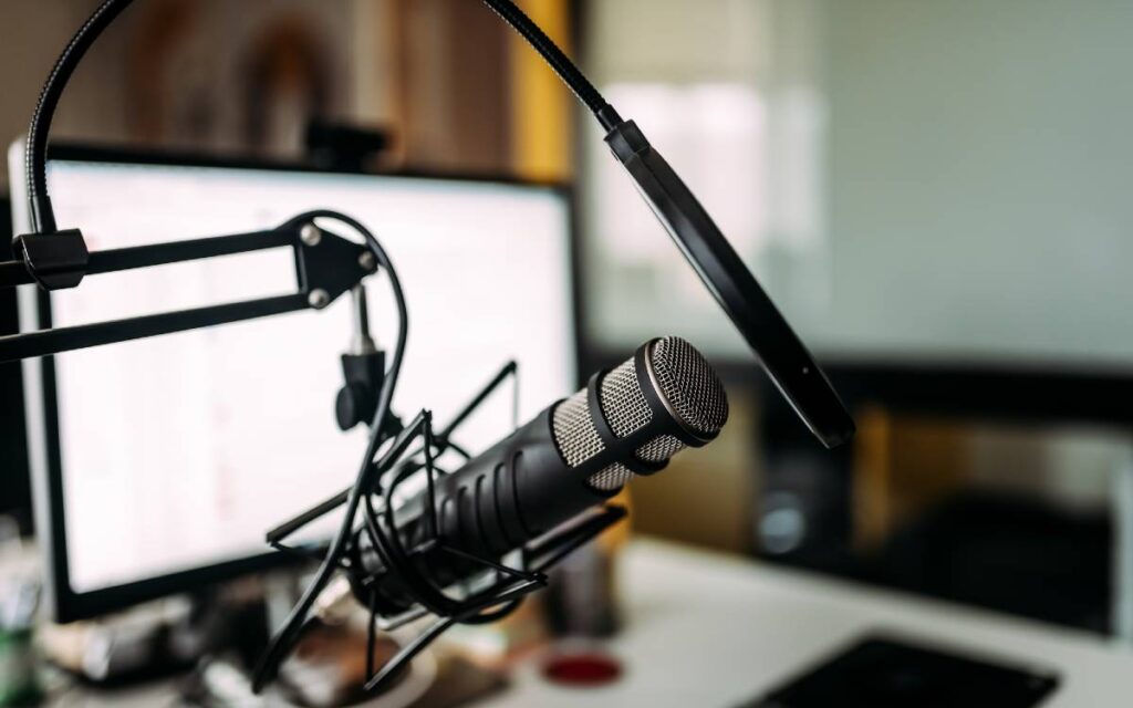 Close up shot of a condenser microphone with blurred computer monitor in the background