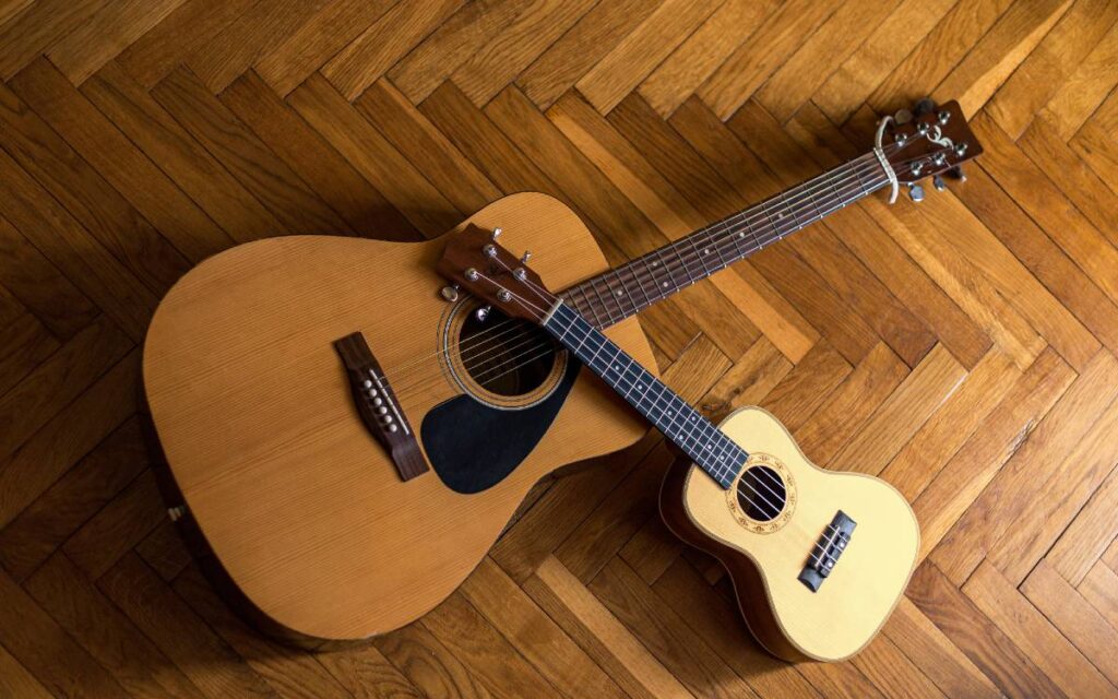 Guitar and ukulele on wooden floor