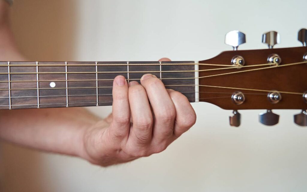 Hand playing an acoustic guitar