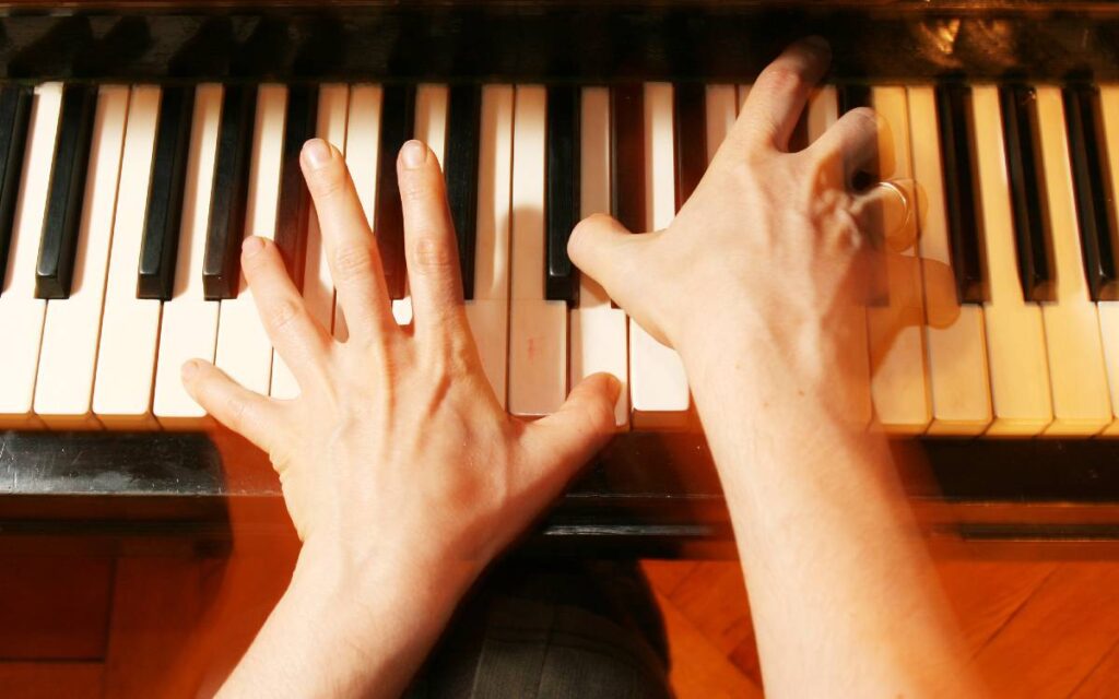 Hands playing the piano