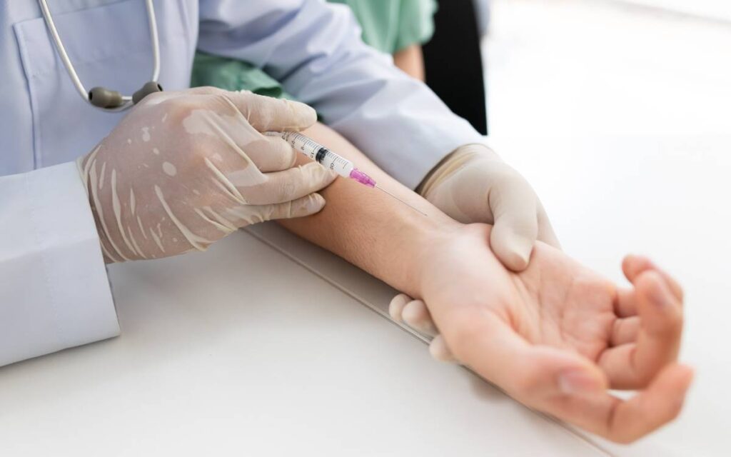 Hands with syringe injecting to wrist