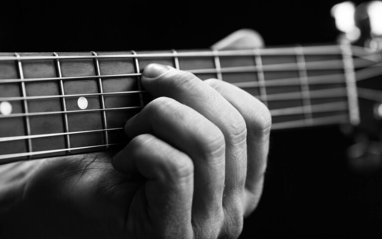 How many guitar chords are there_guitarist hand playing guitar in black and white