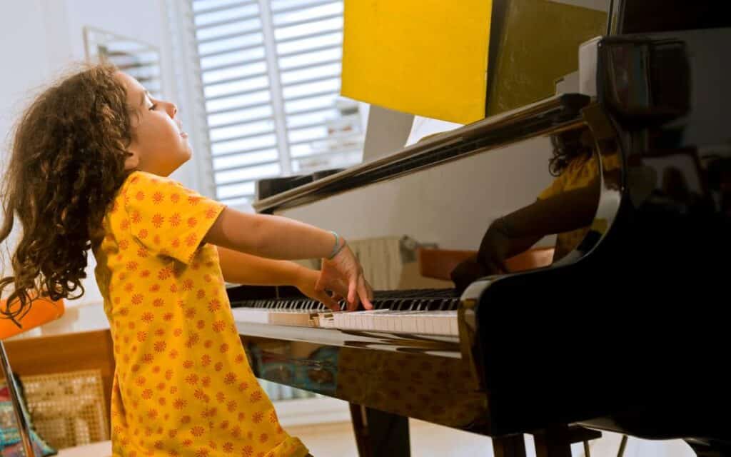 Little girl playing piano enthusiastically