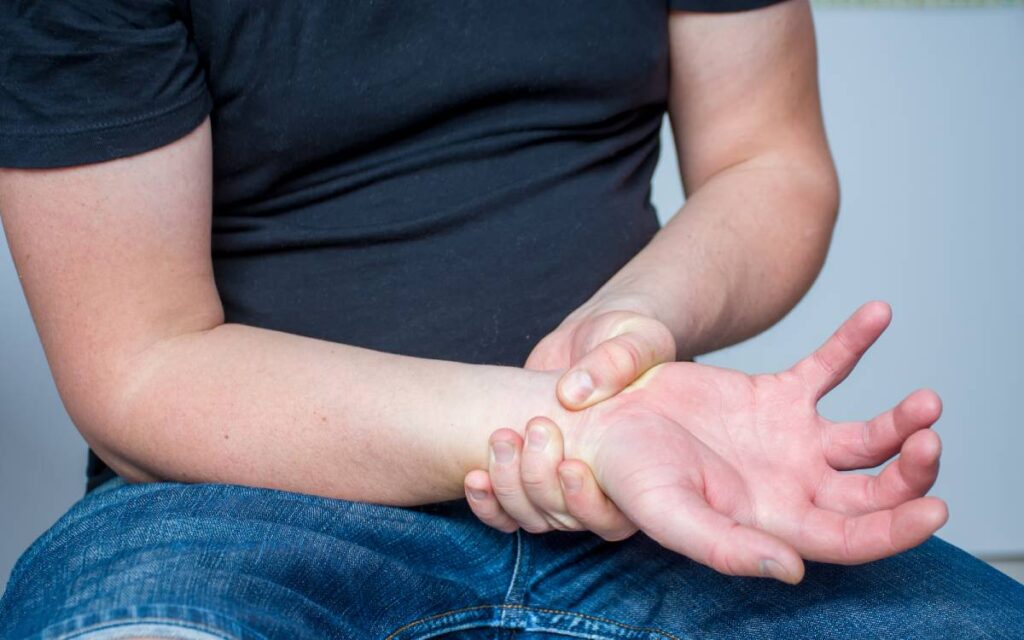 Man suffering from carpal tunnel syndrome holding his wrist