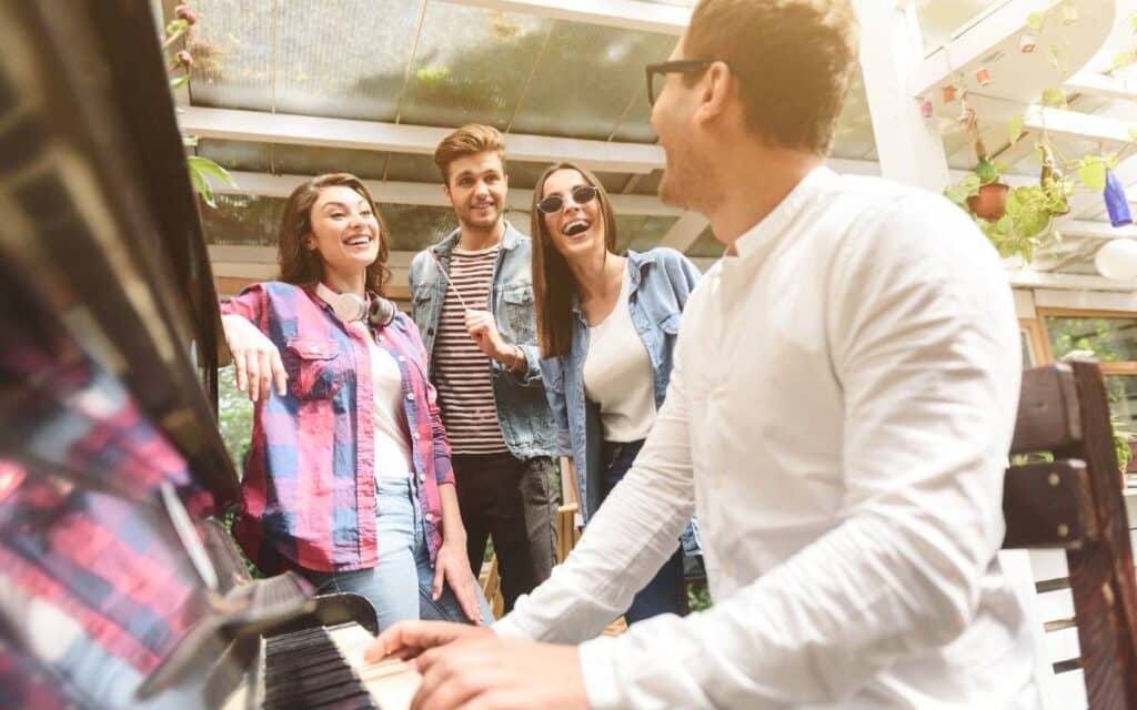 Man talking to people while playing the piano