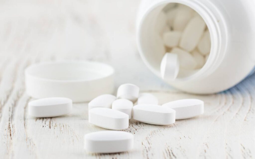 White open jar with scattered tablets