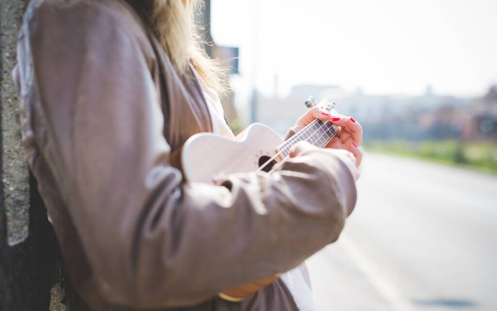 Woman playing ukulele outside