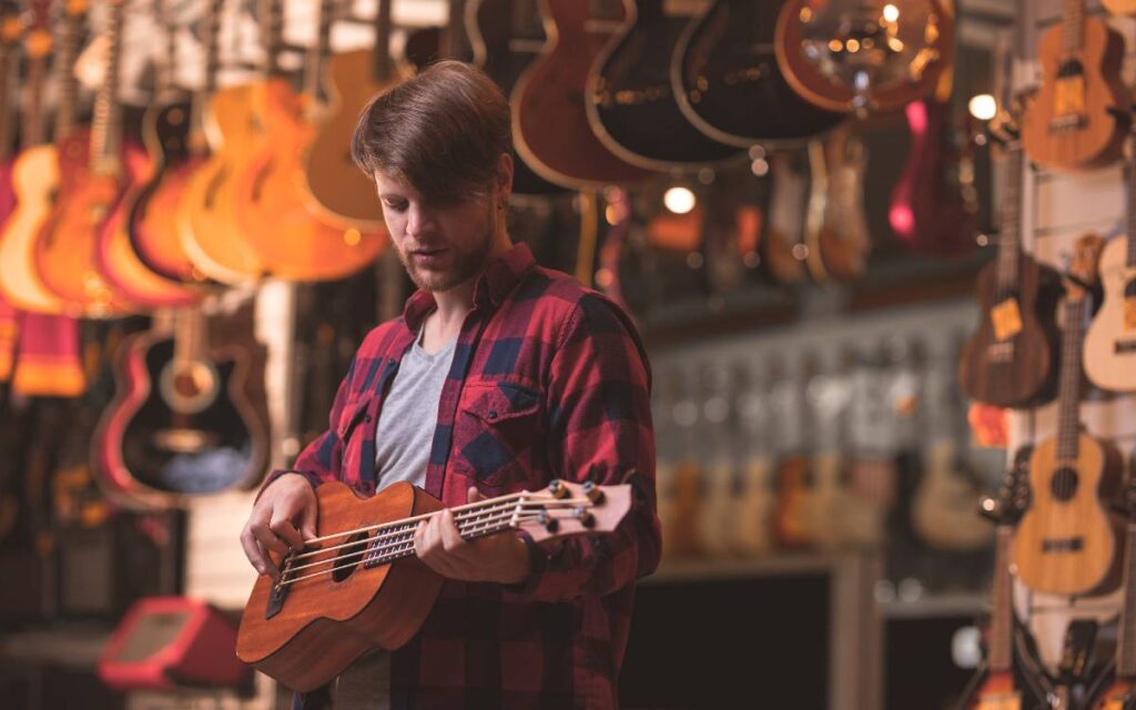 Young man playing ukulele in a music store