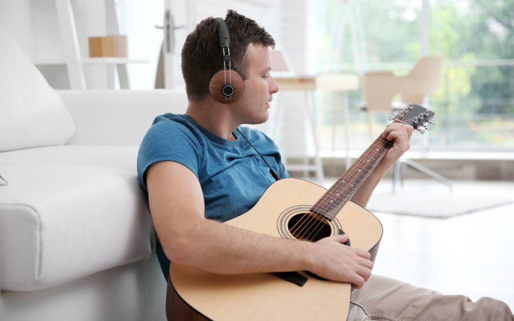 Young man with headphones playing guitar