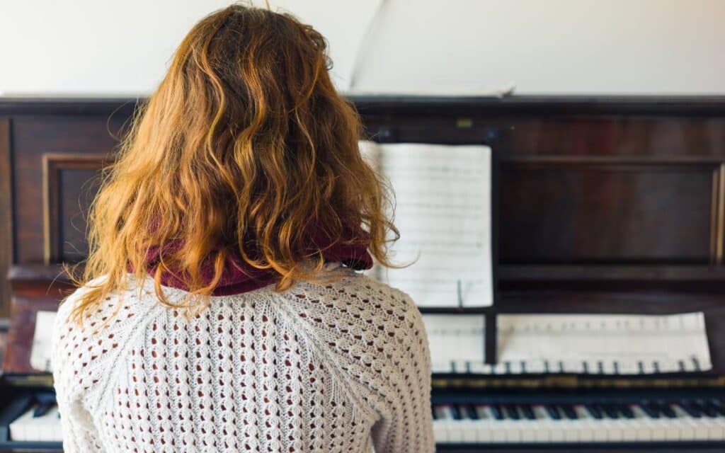 Back view of a girl playing piano
