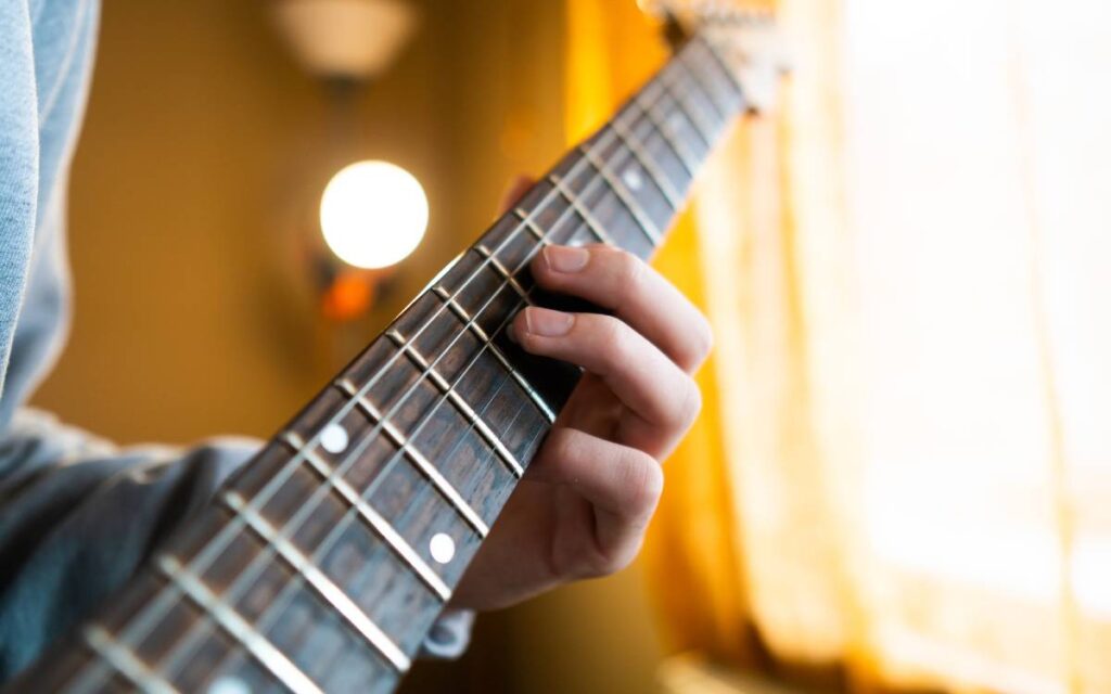 Close up of a guitarist's fingers pressing on guitar strings