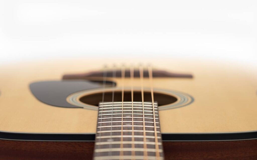 Close up of acoustic guitar on white background, focus on strings