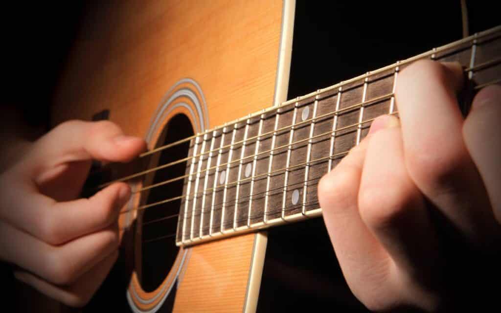 Close up of hands playing the guitar