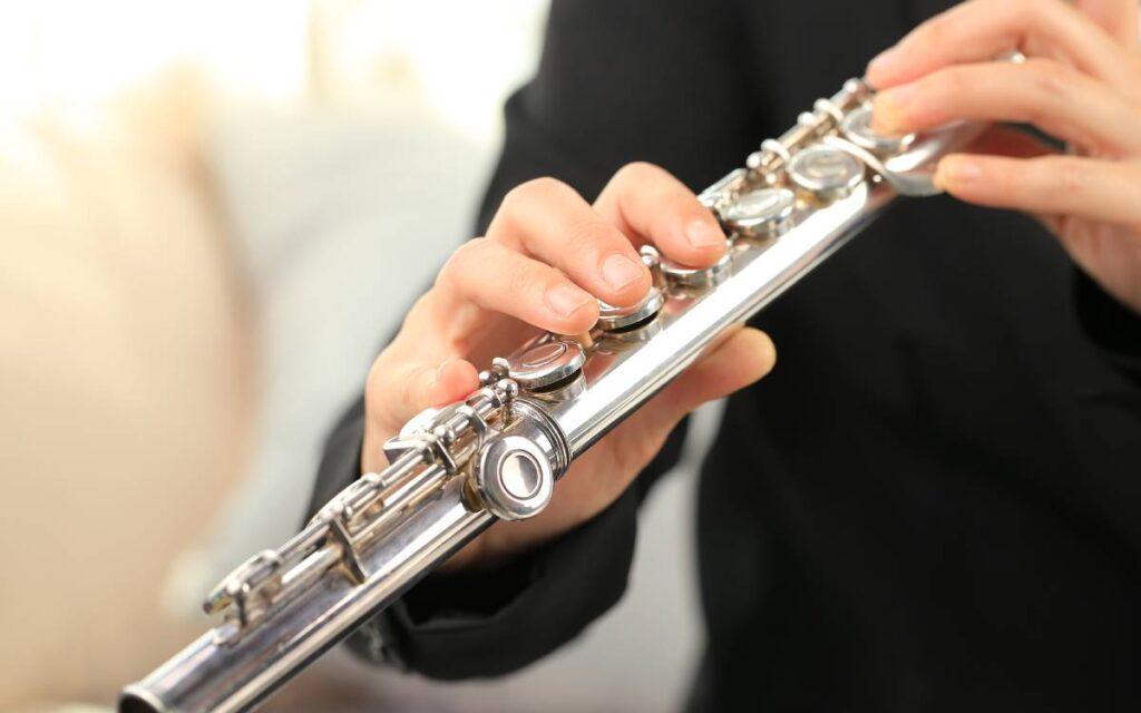 Close up of man's hands playing flute