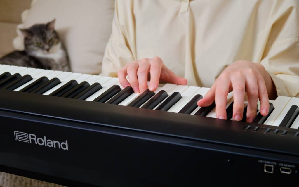 Close up of woman's hands playing roland digital piano