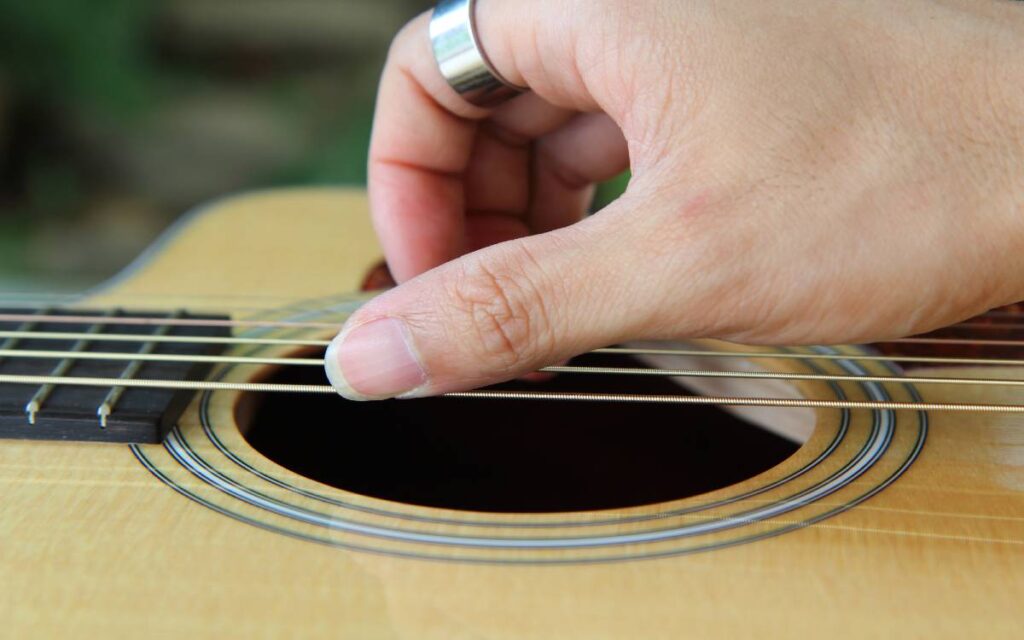 Hand on acoustic guitar strings