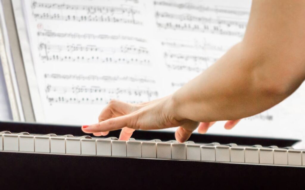 Hands of female pianist playing piano