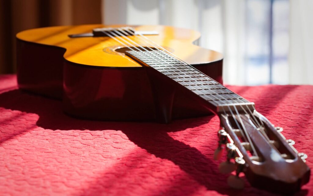 Acoustic guitar on a bed