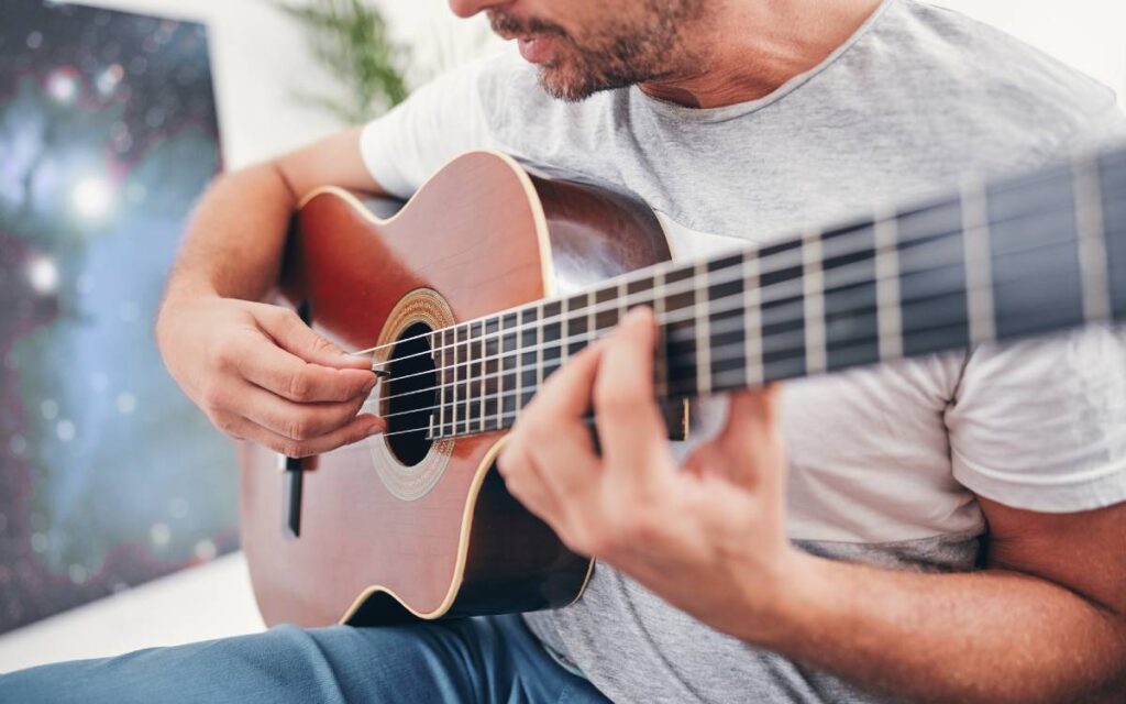 Man playing acoustic guitar in living room