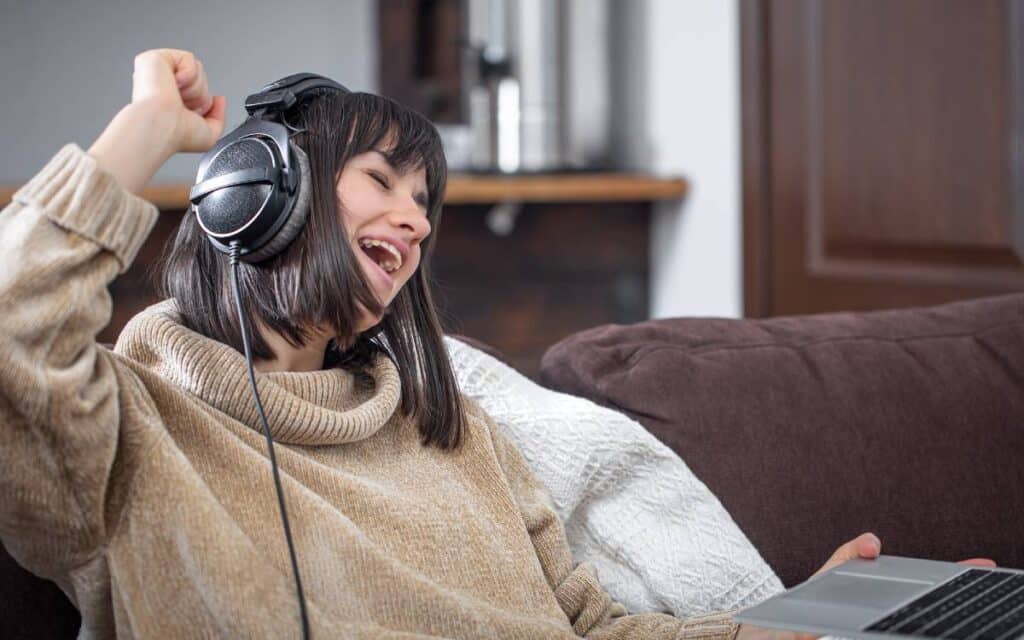 Woman wearing headphones and singing along to a song