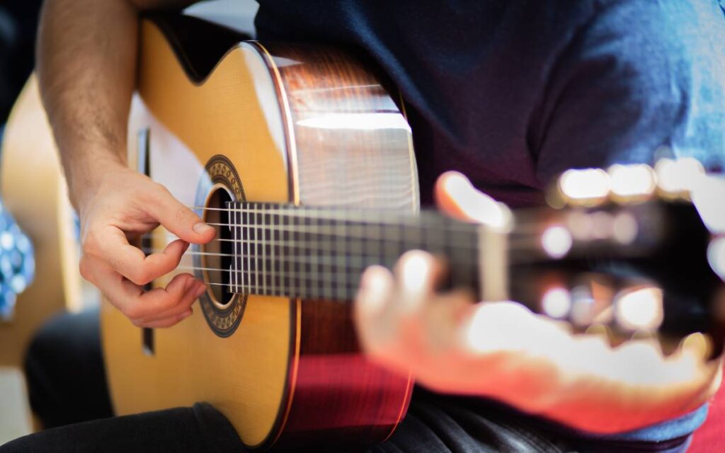 Cropped shot of a man playing an acoustic guitar