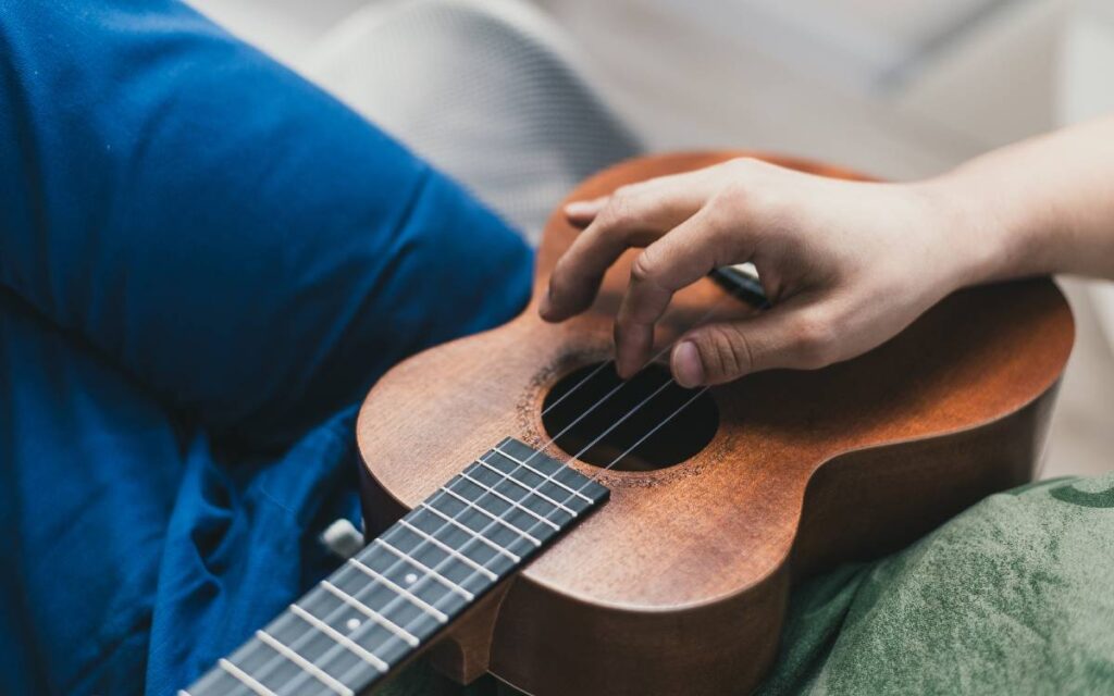 Close up of man's hand playing ukulele