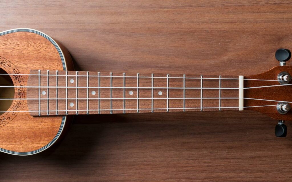 Close up of ukulele neck on wooden table