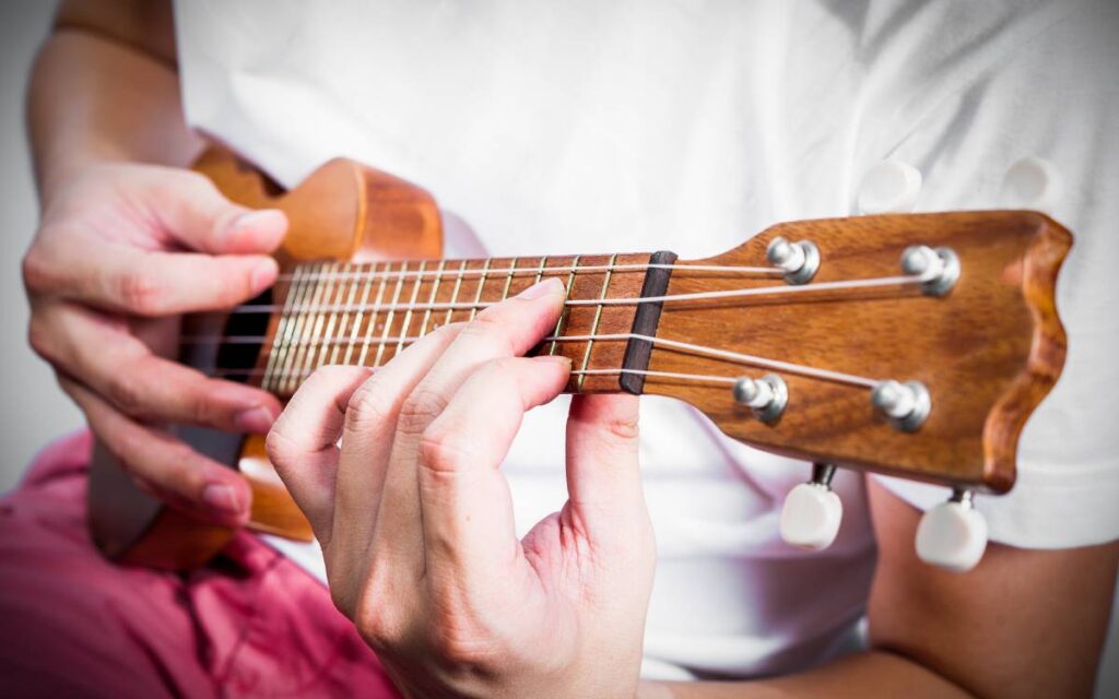 Male hands playing ukulele