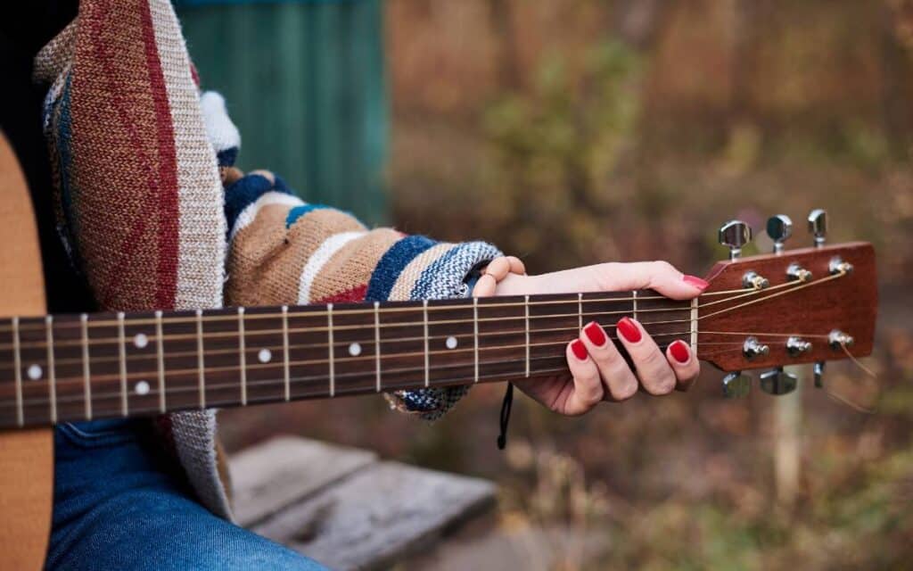 Female hand holding guitar neck