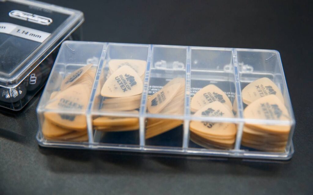 Dunlop ultex guitar picks in a transparent container