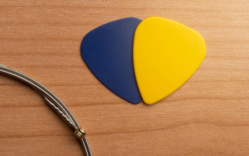 Blue and yellow guitar picks on wooden background