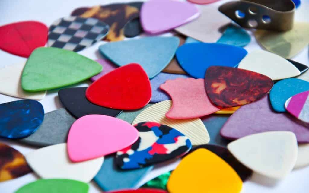 Different types of guitar picks on white background